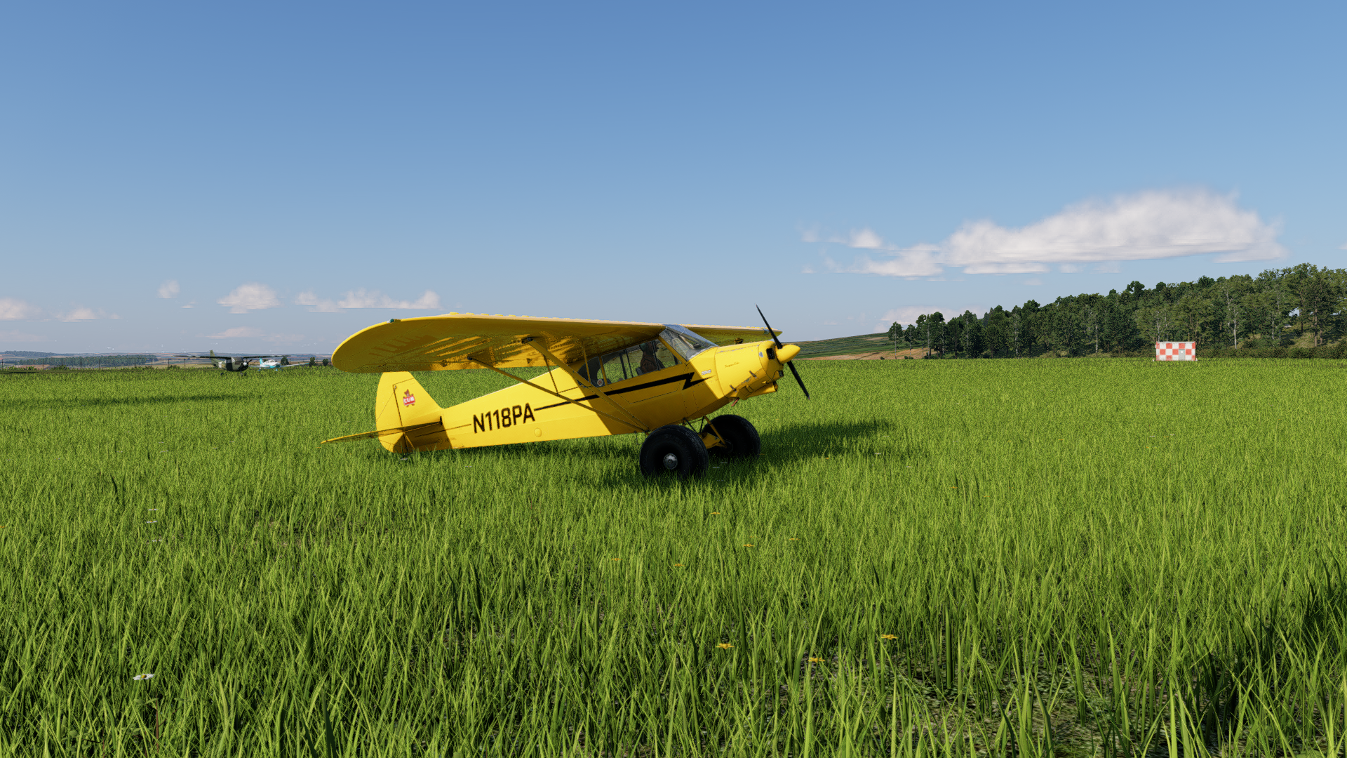 A yellow aircraft parked in an AliveGrass meadow in X-Plane 12